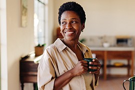 Smiling woman enjoying coffee at home