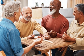 Diverse group of men playing dominoes together