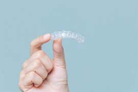 Closeup of patient holding Invisalign aligner