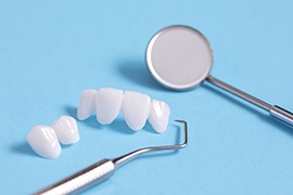 Model veneers lying next to dental tools