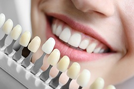 Patient’s teeth being compared to a shade guide
