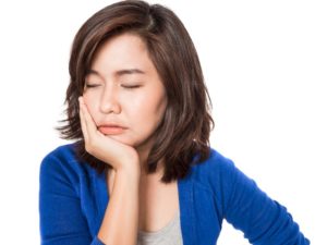 woman holding jaw in pain